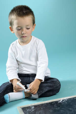 boy preparing to write with chalk on boardの写真素材