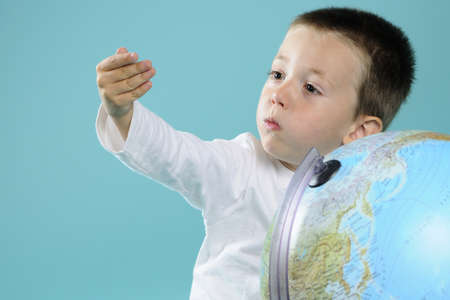 boy evaluating distances on globeの写真素材