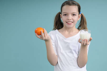 smiling school girl showing healthy foodの写真素材