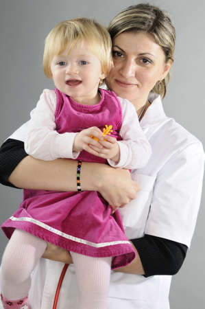 beautiful doctor posing with baby girlの写真素材