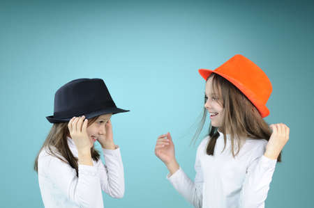 two twin girls having fun with accessoriesの写真素材