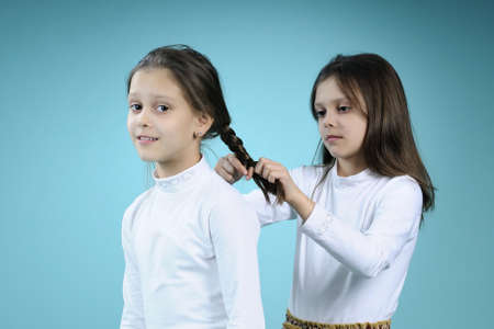cute twins creating braids