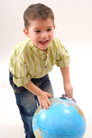 cheerful boy playing with globeの写真素材