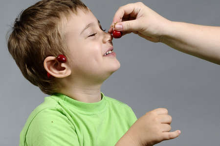 boy playing with cherryの写真素材