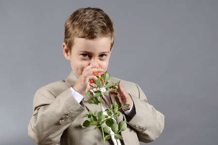 little boy smelling flowerの写真素材