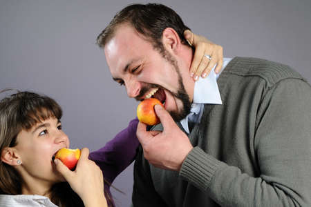 joyful man and girl eating healthy fruits
