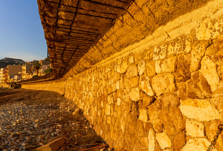 old wall of a stone and concrete quay embankment , leading far along the sea shoreの写真素材