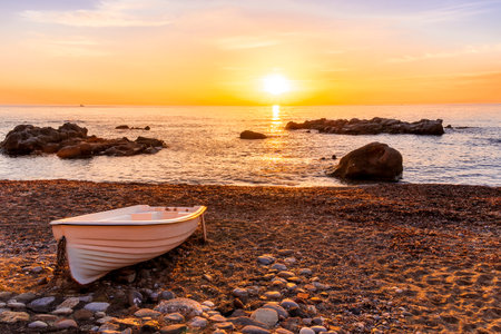 nice old vintage boat on a sea coast with picturesque view on a sunrise in a rocky gulf, landscape of sunset or sunrise bayの写真素材