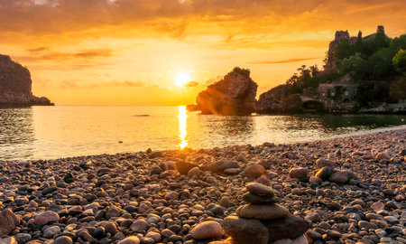 morning or evening landscape with nice beach during sunrise or sunset in sea with amazing isle with rocks and beautiful clouds on backgroundの写真素材