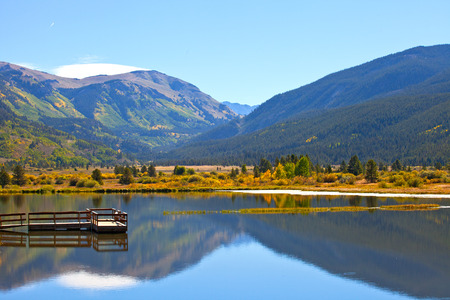Landscape panorama of beautiful mountain nature and lake with reflections in Colorado USA on a sunny day with blue skyの写真素材
