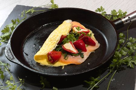 Pepperoni cream with spinach and smoked salmon on a slate and white wood background