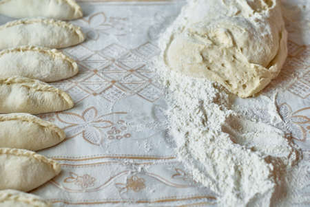 Kitchen, cooking pies with dough on the table, close upの写真素材