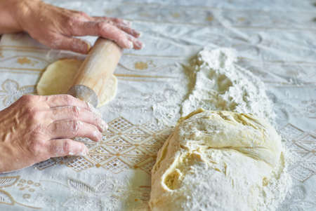 Kitchen, cooking pies with dough on the table, close upの写真素材