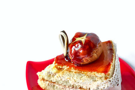 Delicious piece of cake on red saucer, isolated white backgroundの写真素材