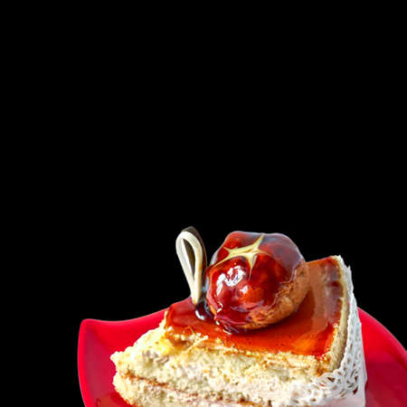 Delicious piece of cake on red saucer, isolated black background with clipping pathの写真素材
