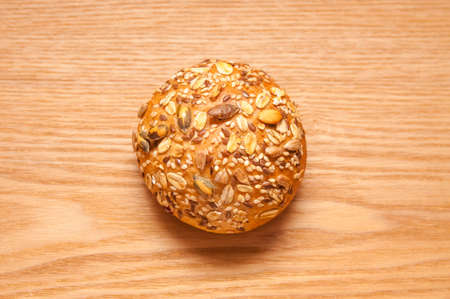 Small cereal bun on beautiful wooden background, top viewの写真素材