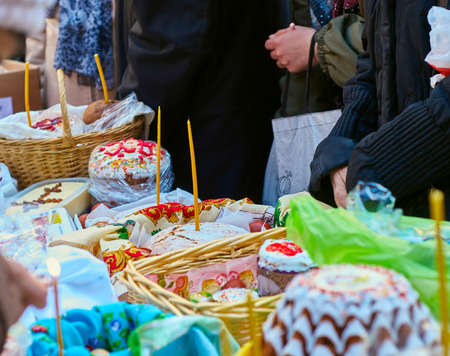 People come to church consecrate Easter cakes and eggs, lit church candles, inserted into the cakesの写真素材