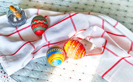 Hand made Easter eggs with embroidered patterns are on kitchen tableの写真素材