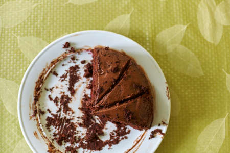 Homemade truffle-cranberry cake chocolate cream cut into pieces on tableの写真素材