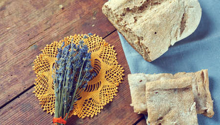 Vintage still life with homemade bread and bunch of dry lavender from aboveの写真素材