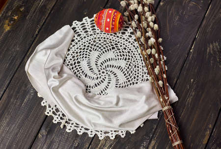 Easter handmade souvenir egg and willow on wooden rustic tableの写真素材