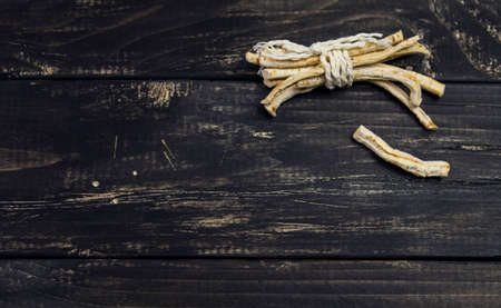 Black wood background with dry roots from aboveの写真素材