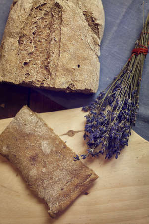 Fresh baked homemade bread and bundle of dry lavender from above close up