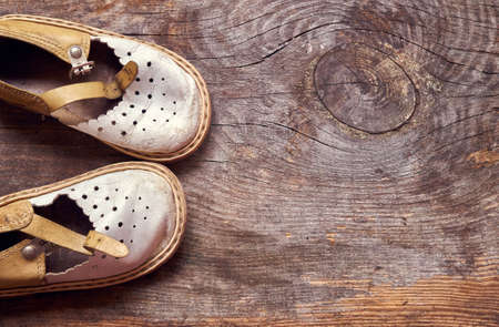 Children vintage shoes on old wood background from above copy spaceの写真素材