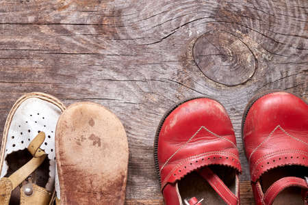Children oldfashioned footwear on vintage wood background top view with copy space