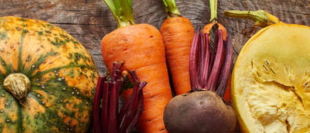 Harvest fresh vegetables on wooden background closeup from above, organic food background