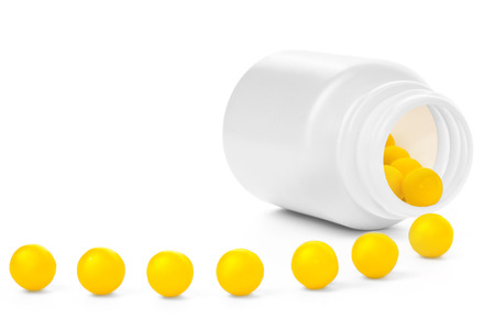 Open plastic medical container with yellow vitaminsの写真素材