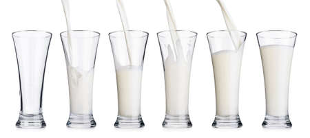 Pouring milk in a glass isolated on white backgroundの写真素材
