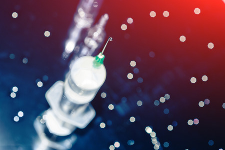 Medical syringe with a drop at the end of the needleの写真素材