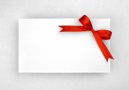 Red silk bow on empty paper cardの写真素材