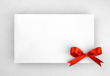 Red silk bow on empty paper cardの写真素材