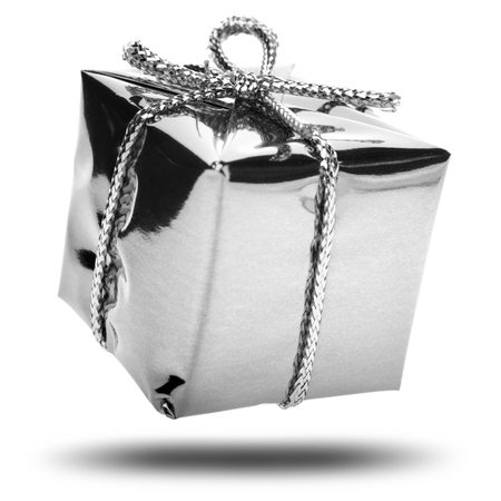 Silver gift with a silver ribbon and a bow falling on white backgroundの写真素材