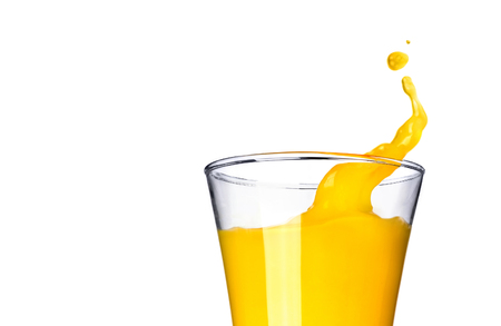 Splashing orange juice in glass on white backgroundの写真素材