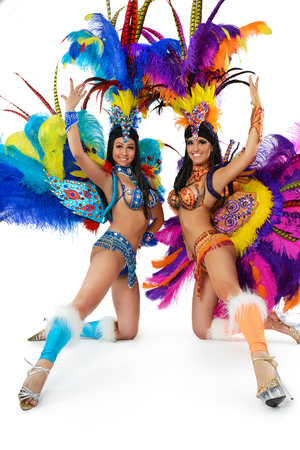 Two smiling beautiful girls in a colorful carnival costume