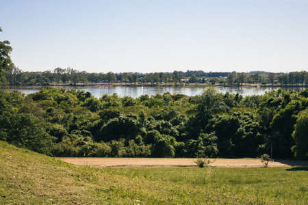 A green and beautiful park at the side of the river on a sunny dayの写真素材