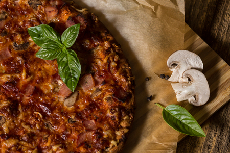 Pizza with mushrooms, salami and wegetable on the old wustic wood tableの写真素材