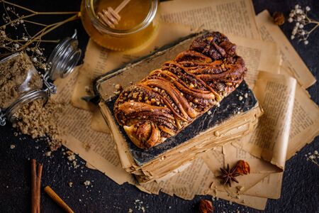 Traditional Polish babka cake with walnut. Still life of swirl brioche or walnut braided bread on dark textured tableの写真素材