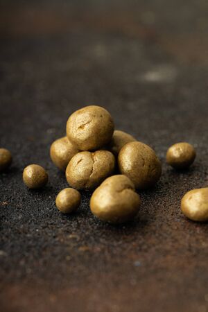Sweet spiced handcrafted pralines on rustic textured dark background.
