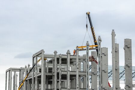 Workers build a new stadion. Concrete and steel building. Construction with a crane