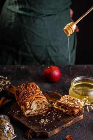 Traditional Polish babka cake with walnut. Still life of swirl brioche or walnut braided bread on dark textured tableの写真素材