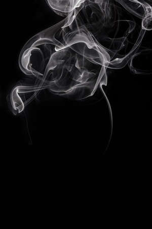 Abstract white smoke or steam swirls on black backgroundの写真素材
