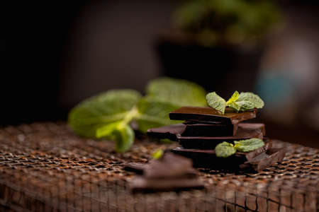 dark or milk chocolate bars with green mint leafの写真素材
