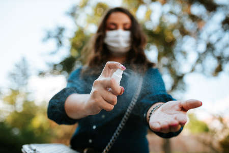 Corona virus lifestyle concept of a young women in city street who walks with surgical or protecting mask during pandemic.の写真素材