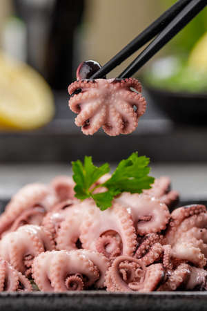 Delicious mini boiled octopus and fresh wakame seaweed salad with sesame seeds, lemon and soy sauce....