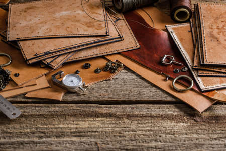 Leather craft tools on old wood table. Leather craft workshop.の写真素材