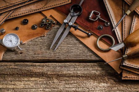 Leather craft tools on old wood table. Leather craft workshop.の写真素材